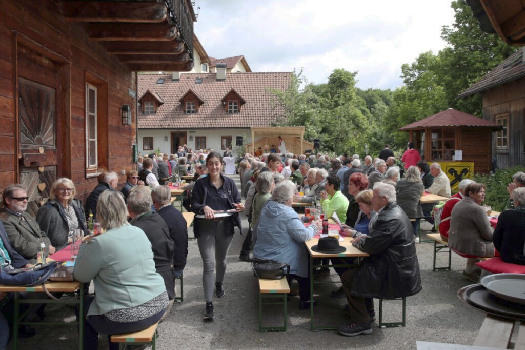 Dorffest am Dorfplatz mit vielen Menschen auf Heurigen-Garnituren im Steinschaler Dörfl bei Veranstaltung